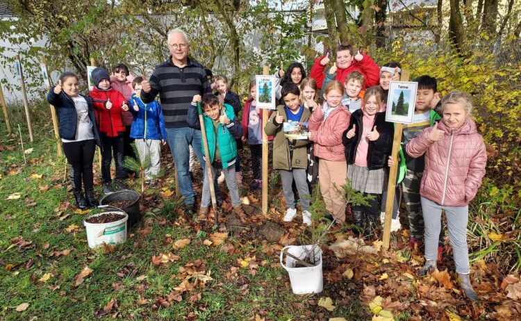 Gruppenfoto der Schüler der Graslitzer Grundschule mit Stadtgärtner Christian Stöckl beim Pflanzen der Bäume: Zum Vergrößern auf Bild klicken
