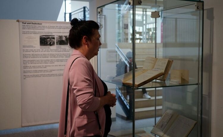 Besucherin beim Betrachten einer Vitrine mit Büchern.: Zum Vergrößern auf Bild klicken