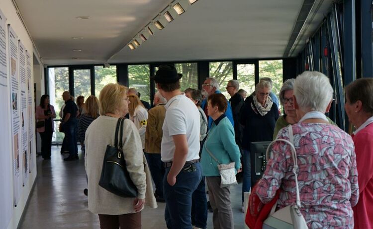 Ausstellungsbesucherinnen und Besucher in der Ausstellung: Zum Vergrößern auf Bild klicken