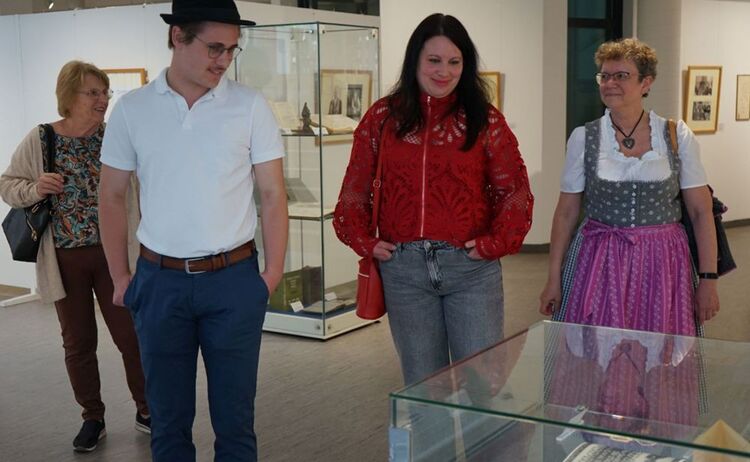 Besucher und Besucherinnen beim Betrachten einer Vitrine: Zum Vergrößern auf Bild klicken