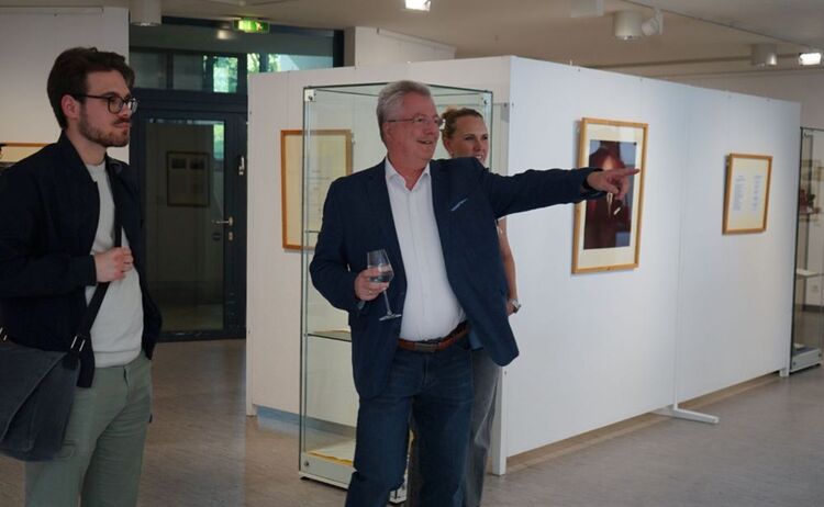 Ausstellungsbesucher beim Betrachten von Ausstellungsobjekten: Zum Vergrößern auf Bild klicken