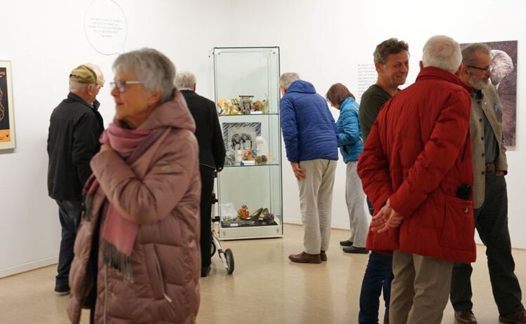 Besucherinnen und Besucher vor der Vitrine mit der Sammlung von verschiedensten Elefanten: Zum Vergrößern auf Bild klicken